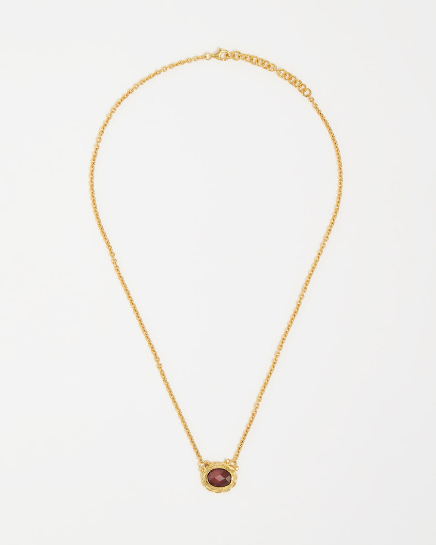 product shot of yellow gold plated silver necklace with a red crystal pendant