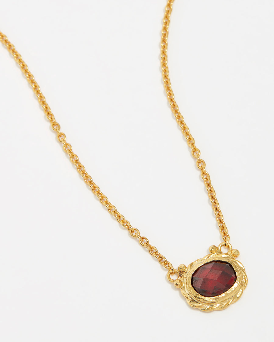 product shot of yellow gold plated silver necklace with a red crystal pendant