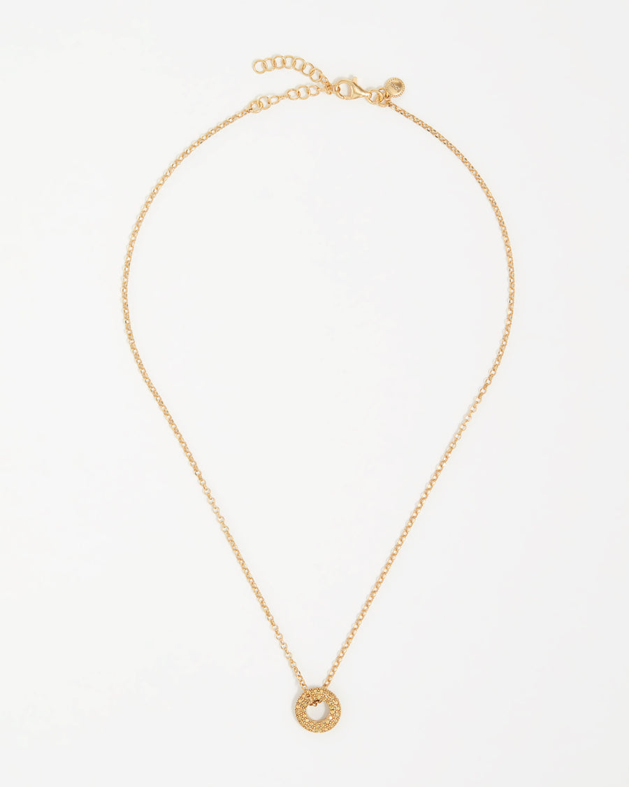 product shot of yellow gold plated necklace with circular pendant threaded through the chain