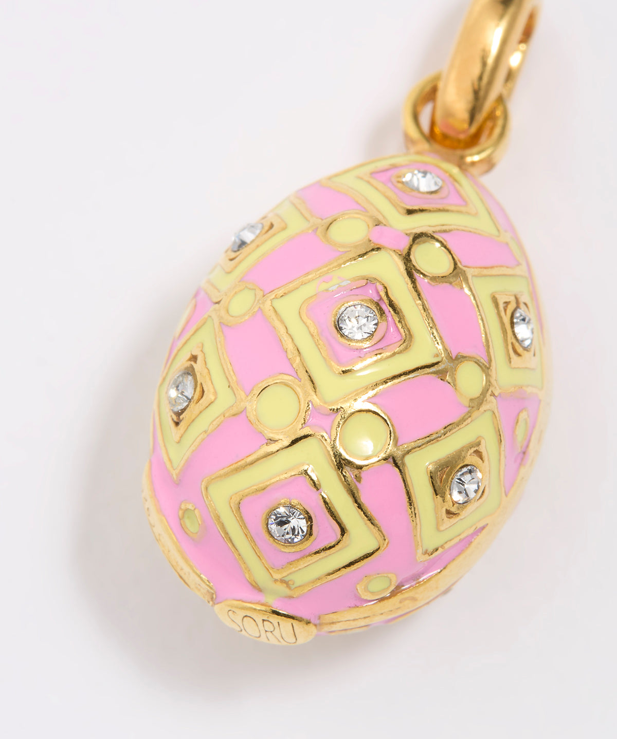 Pink and gold egg-shaped pendant with decorative patterns on a white background