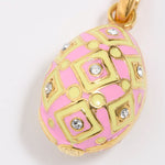 Pink and gold egg-shaped pendant with decorative patterns on a white background