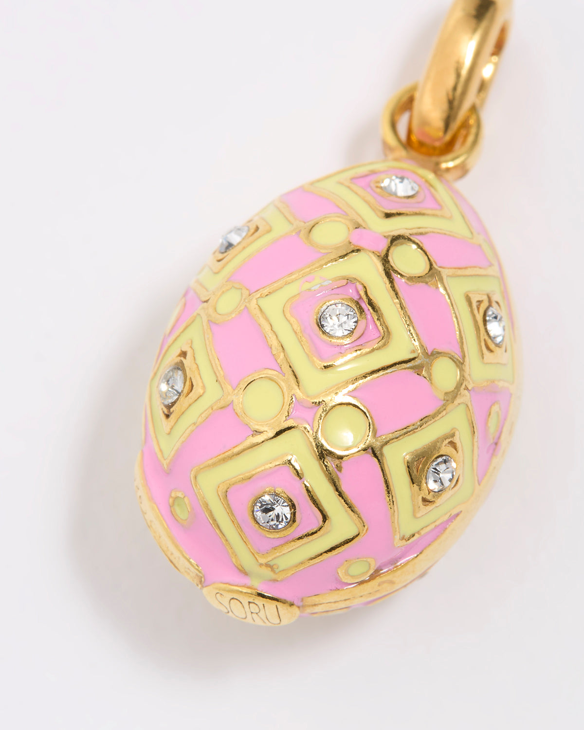 Pink and gold egg-shaped pendant with decorative patterns on a white background