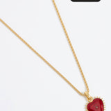 Product shot of Soru Jewellery red heart charm hung from a rope charm chain on white background