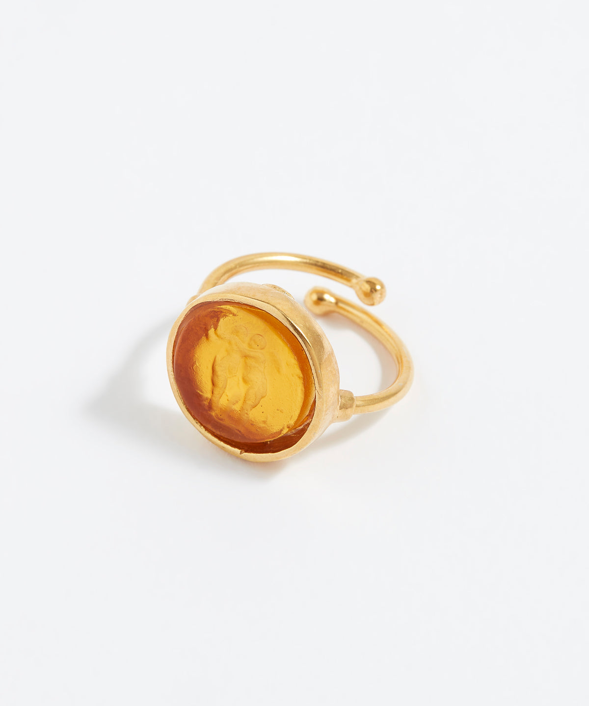 Gold ring with a yellow stone on a white background