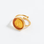 Gold ring with a yellow stone on a white background