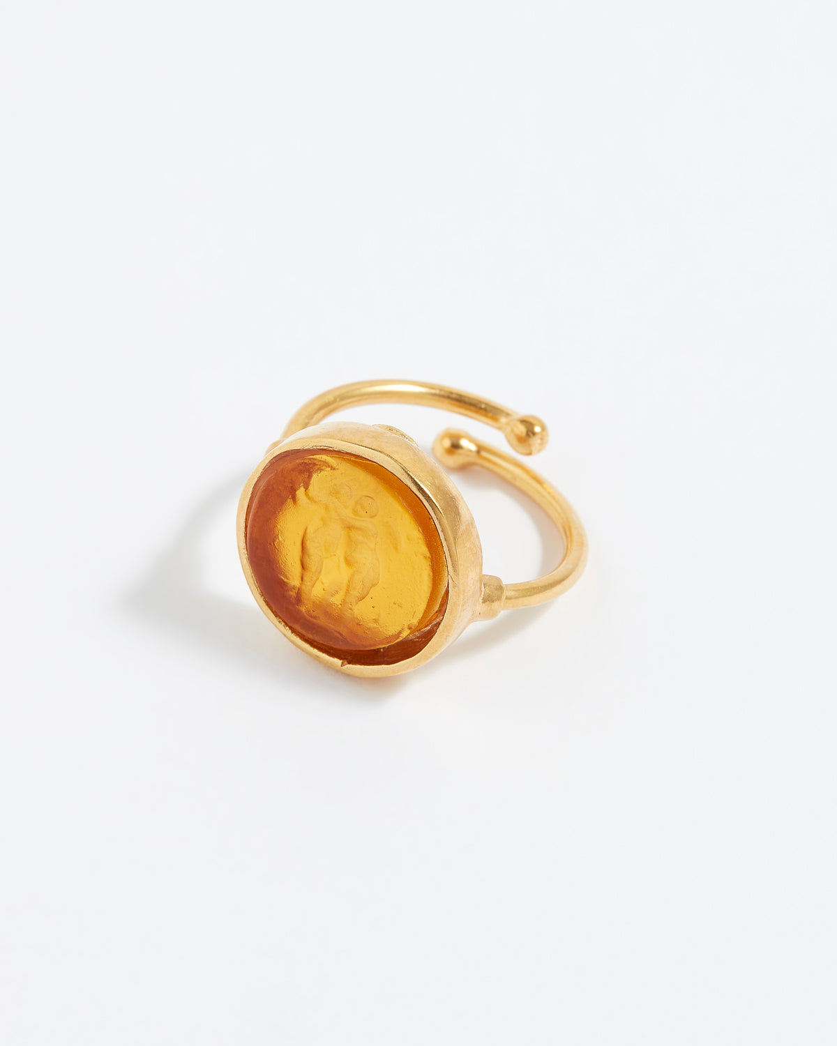 Gold ring with a yellow stone on a white background