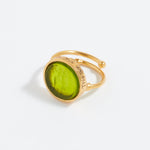 Gold ring with a green stone on a white background