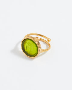 Gold ring with a green stone on a white background