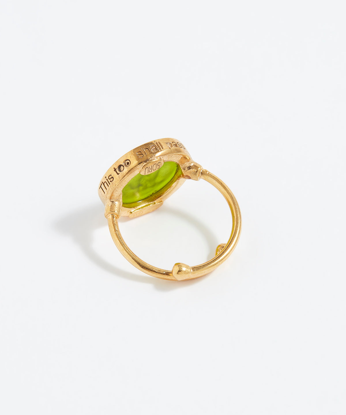 Gold ring with a green gemstone on a white background