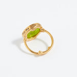 Gold ring with a green gemstone on a white background