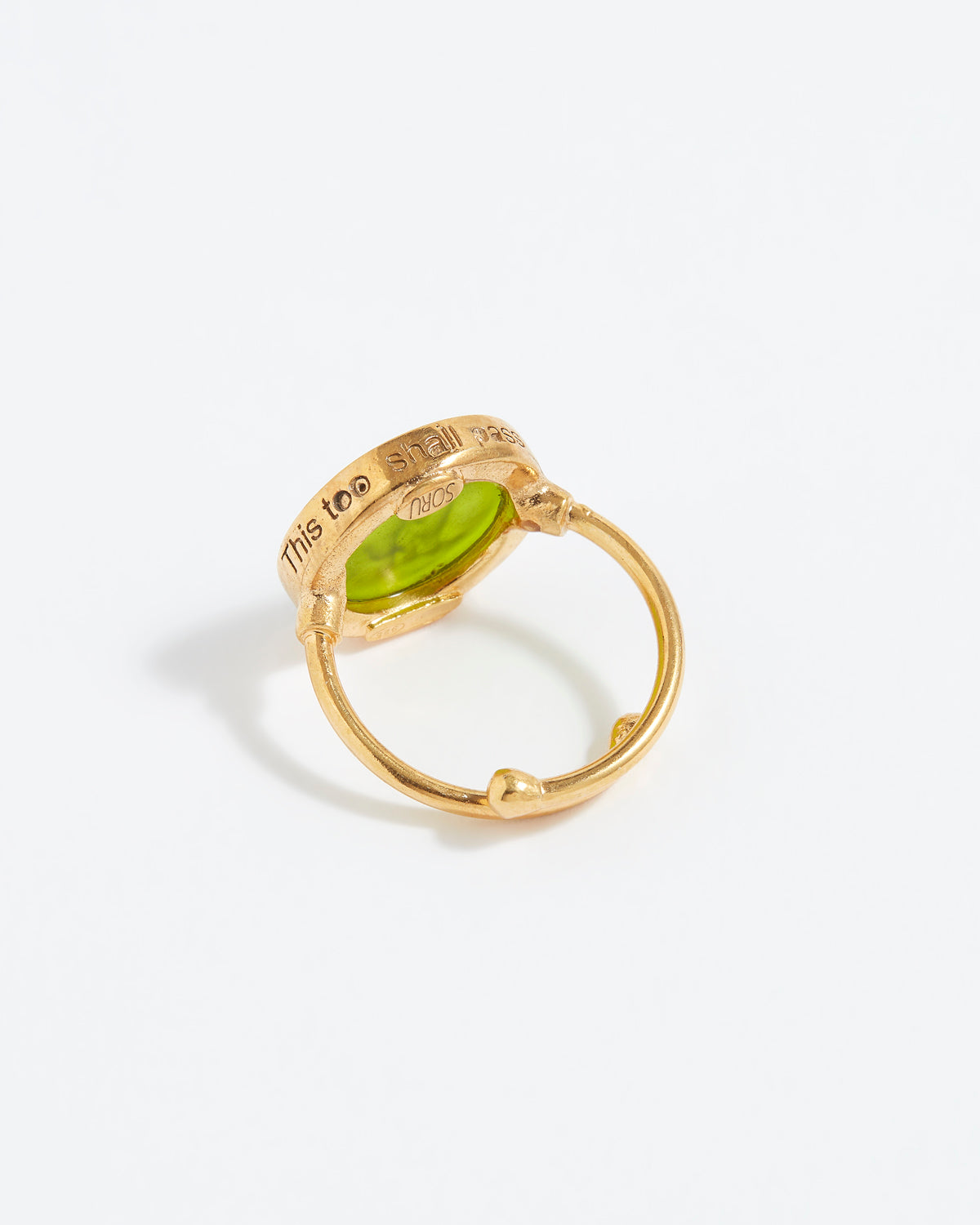Gold ring with a green gemstone on a white background