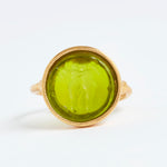 Gold ring with a green stone on a white background