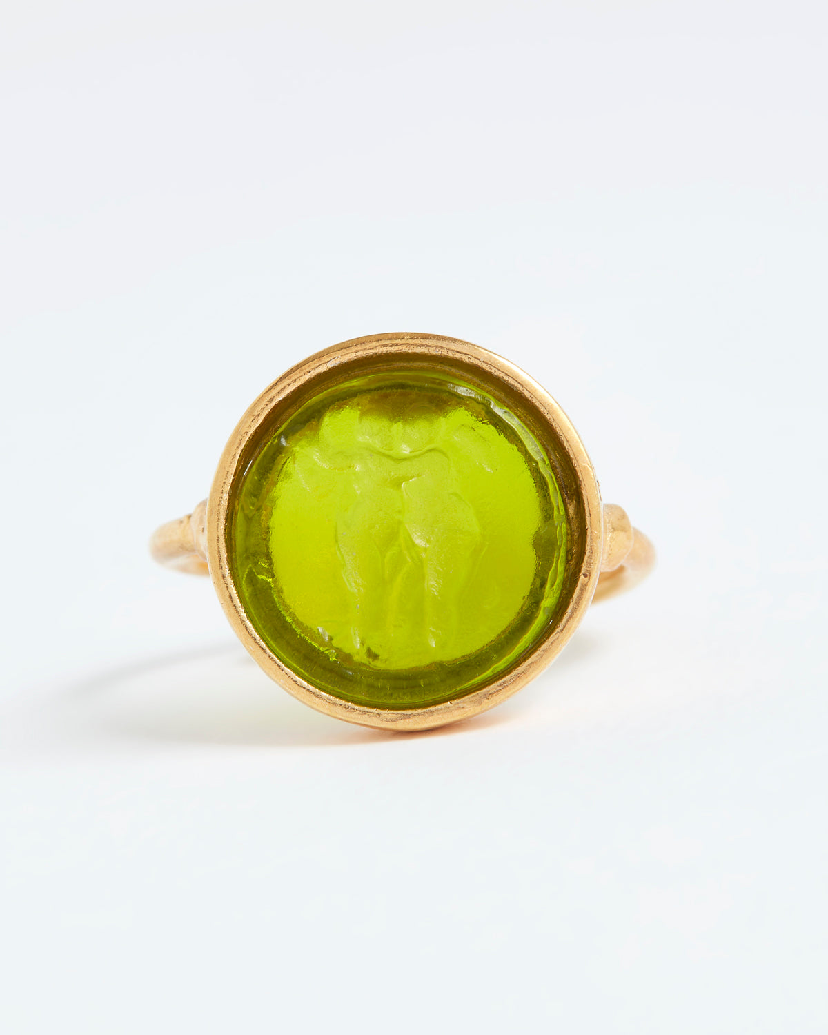 Gold ring with a green stone on a white background