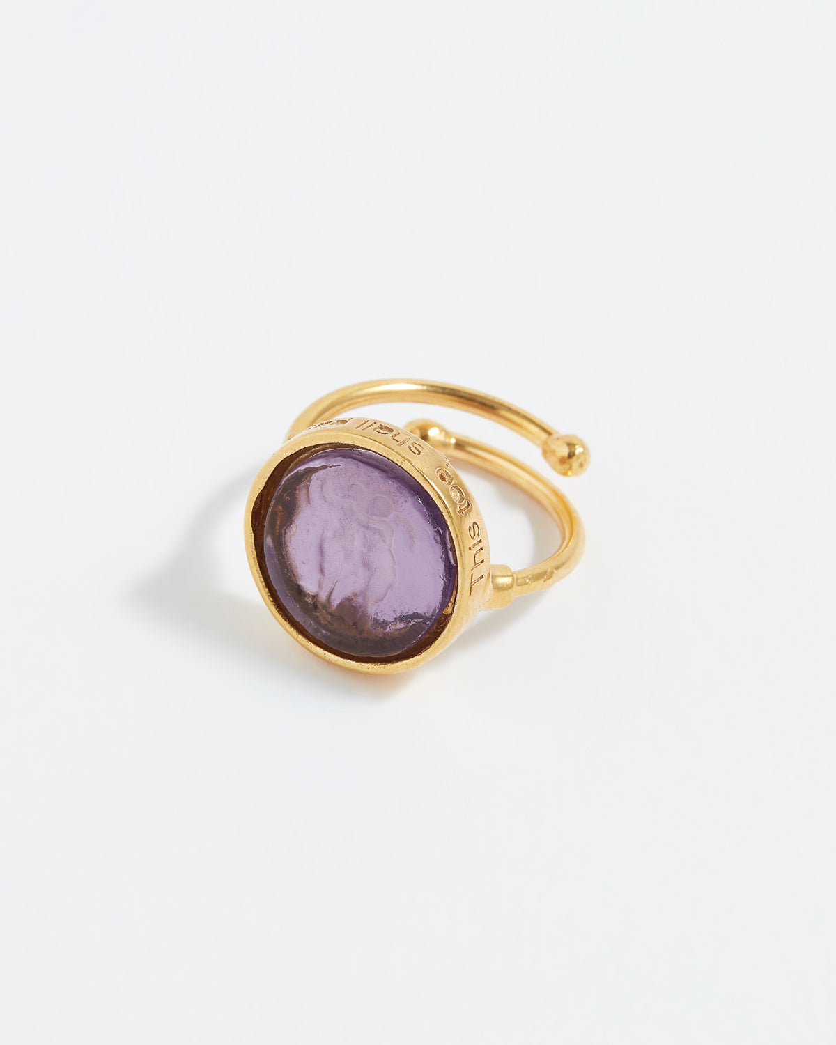 Gold ring with a purple gemstone on a white background