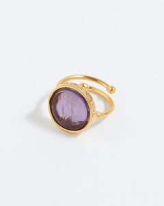 Gold ring with a purple gemstone on a white background
