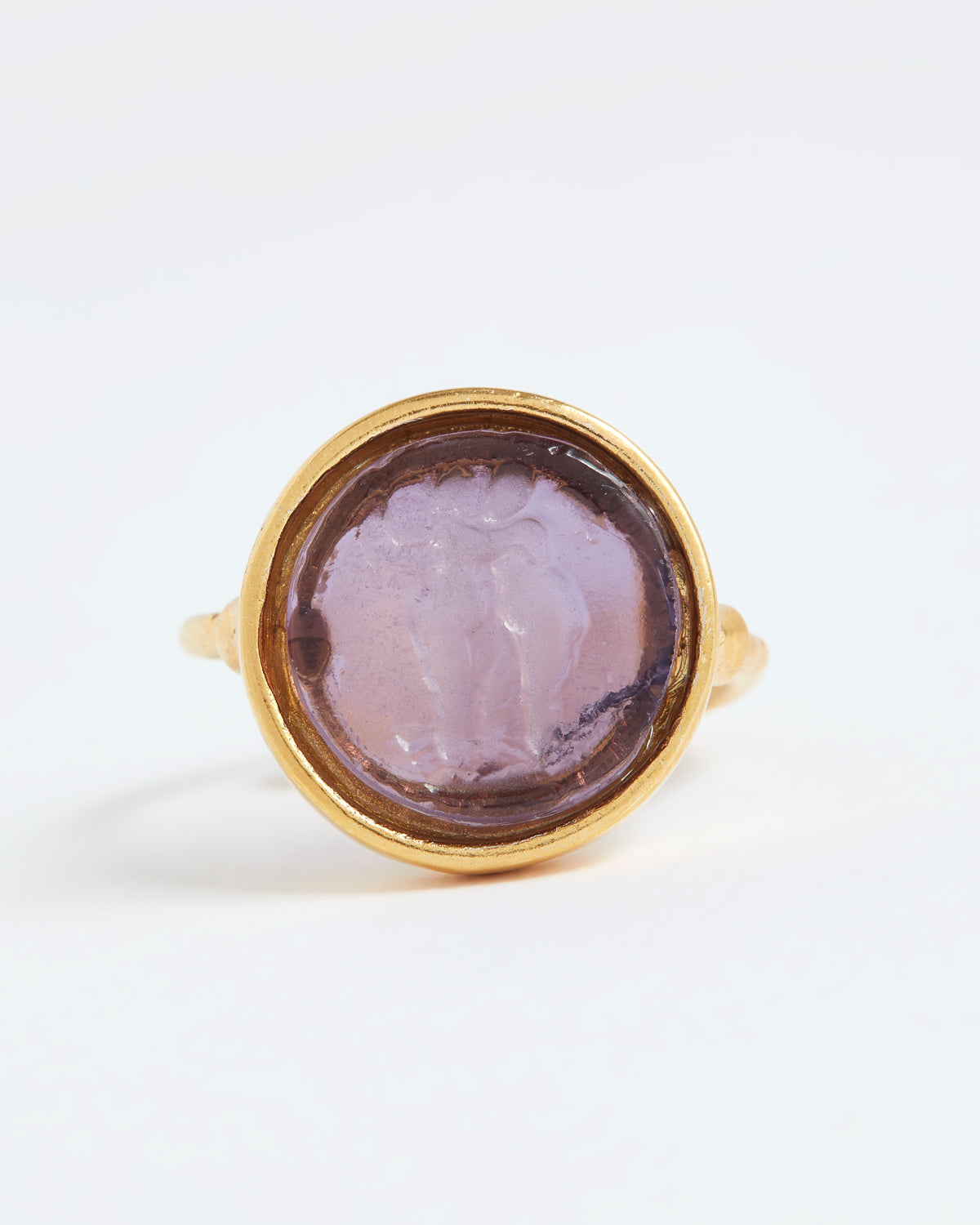 Gold ring with a purple stone on a white background