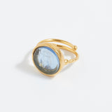 Gold ring with a blue stone on a white background