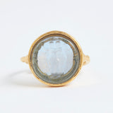 Gold ring with a circular stone on a white background