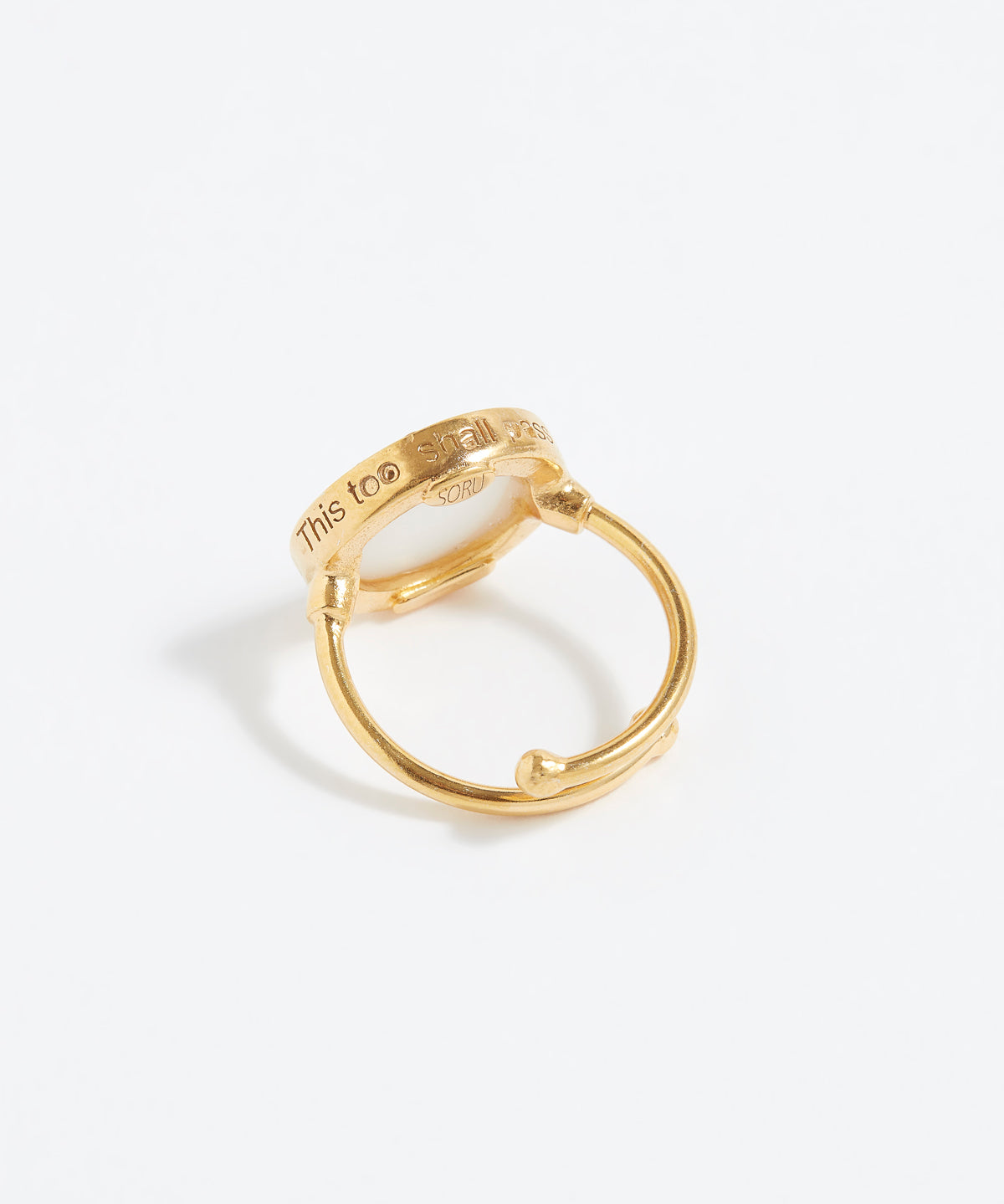 Gold ring with engraved text "This Too Shall Pass" on a white background
