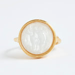 Gold ring with a white stone inlay on a white background