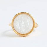 Gold ring with a white stone inlay on a white background