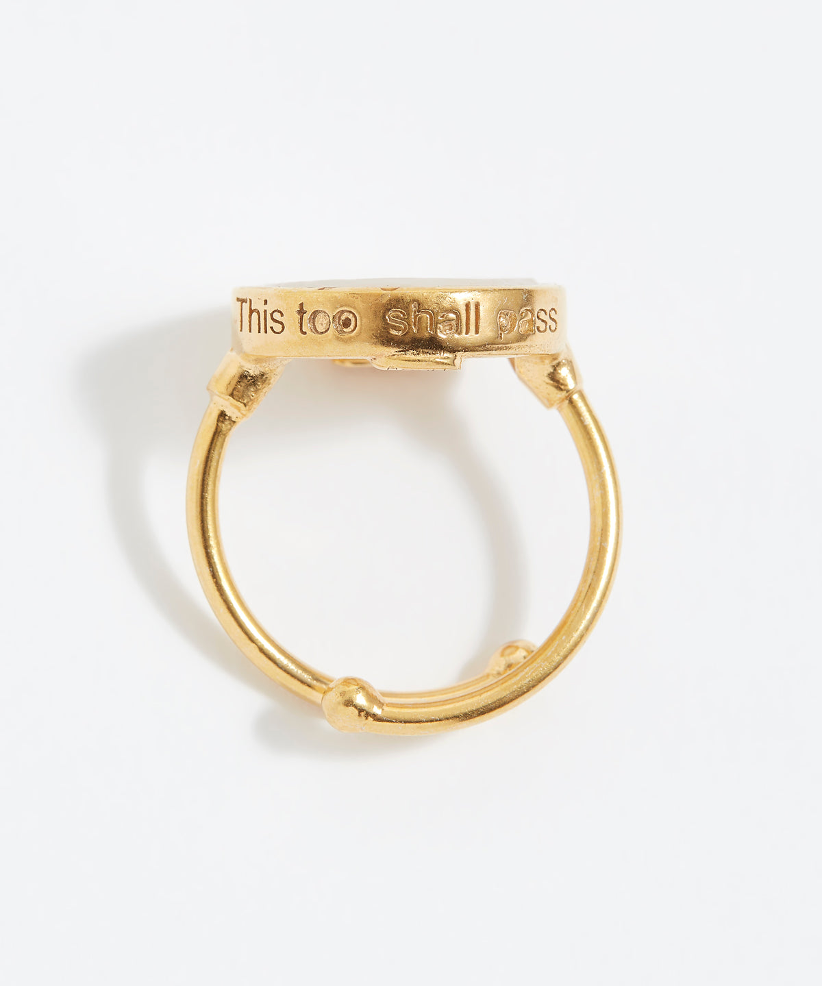 Gold ring with 'This too shall pass' engraving on a white background