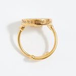 Gold ring with 'This too shall pass' engraving on a white background