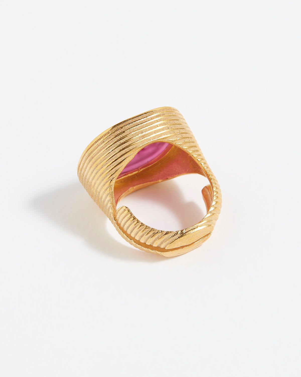 Gold ring with pink centre on a white background