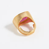 Gold ring with pink centre on a white background