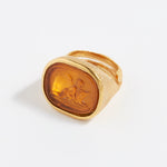 Gold ring with a engraved design on a white background