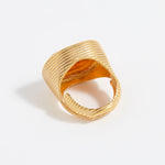 Gold ring with textured design on a white background