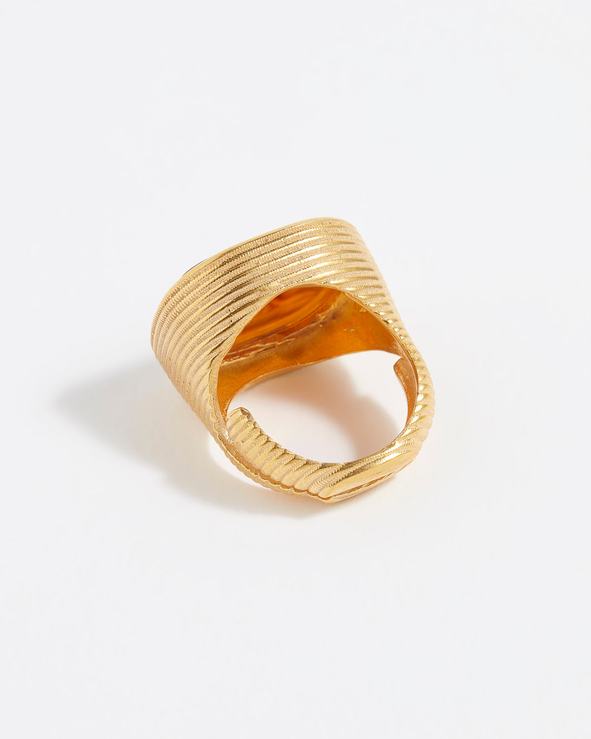 Gold ring with textured design on a white background