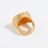 Gold ring with textured design on a white background