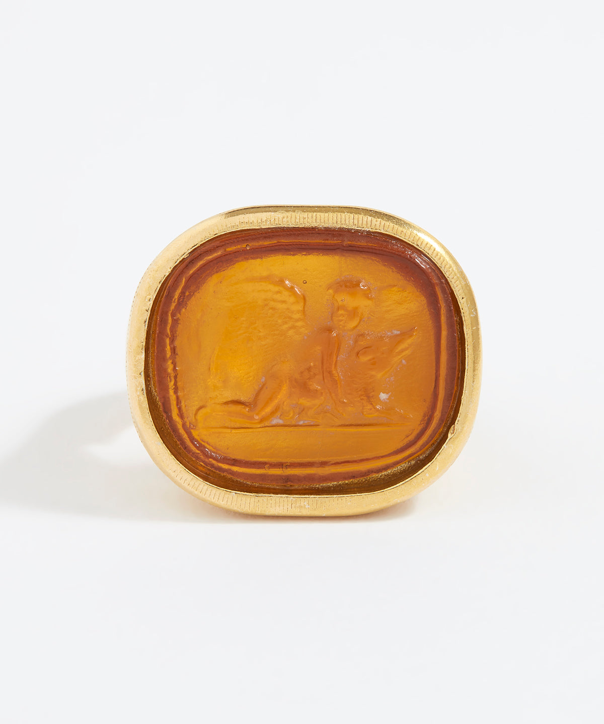 Gold ring with a topaz-colored stone on a white background