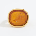 Gold ring with a topaz-colored stone on a white background