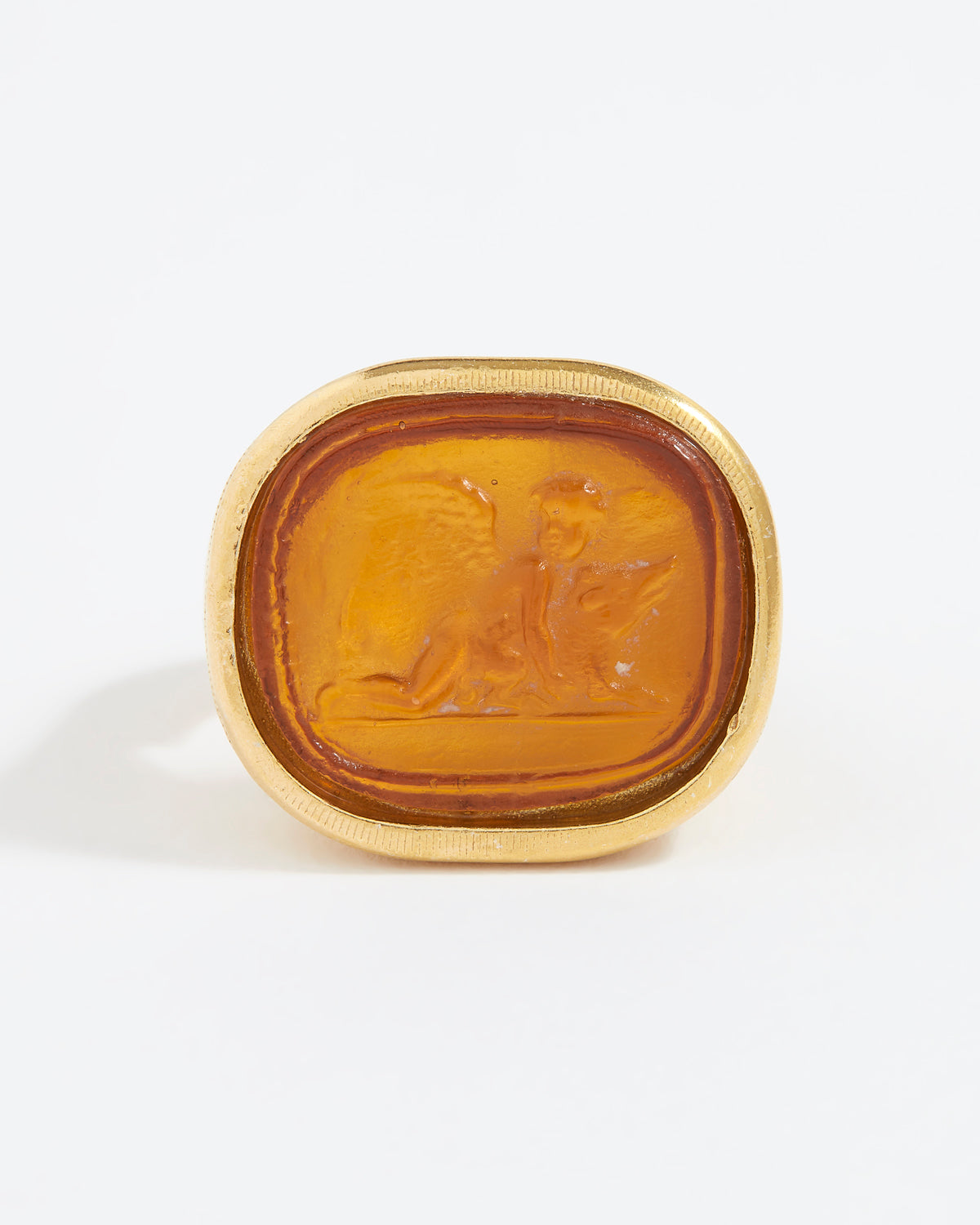 Gold ring with a topaz-colored stone on a white background