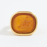 Gold ring with a topaz-colored stone on a white background