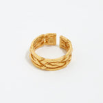 close up image shot of gold braided ring on a white back ground