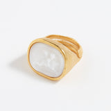 Gold ring with a white stone on a white background