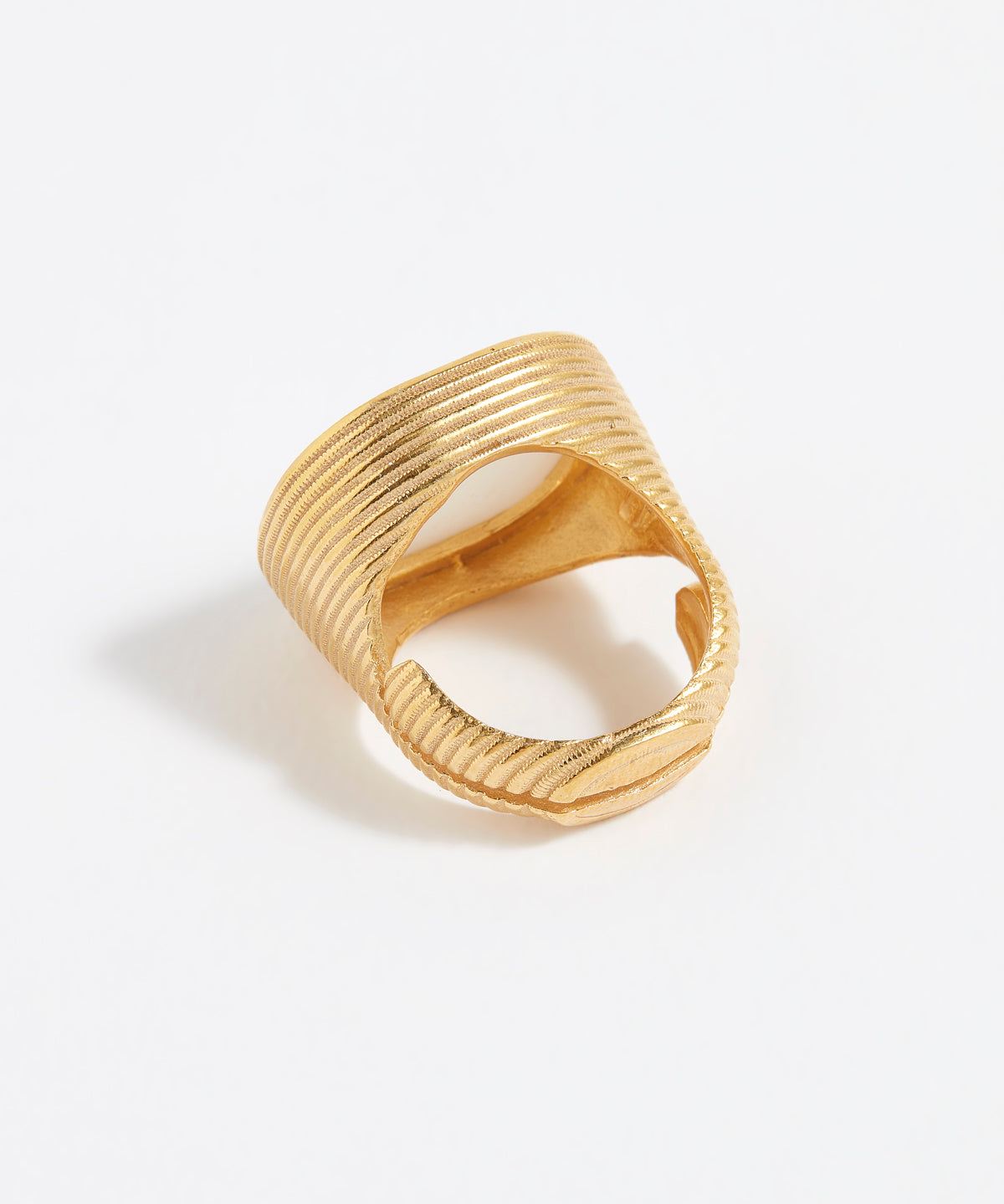 Gold ring with textured design on a white background