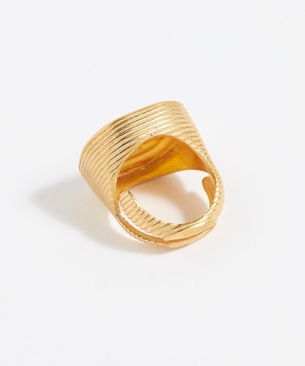 Gold ring with textured design on a white background