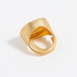 Gold ring with textured design on a white background
