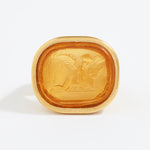 Gold ring with engraved design on a white background