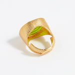 Gold ring with a green stone on a white background
