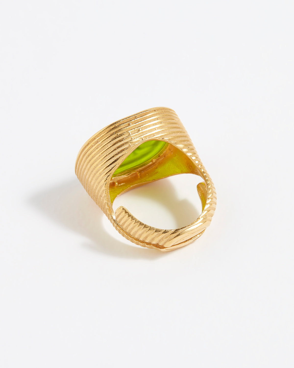 Gold ring with a green stone on a white background