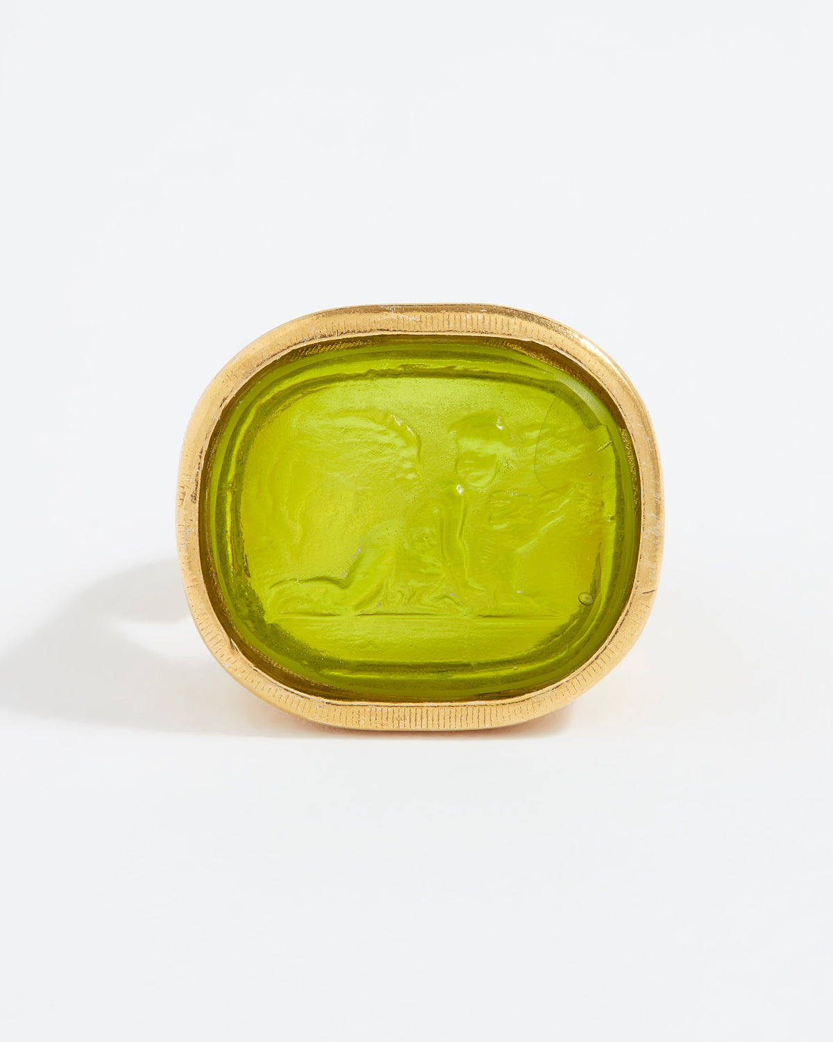 Green stone ring with gold setting on a white background