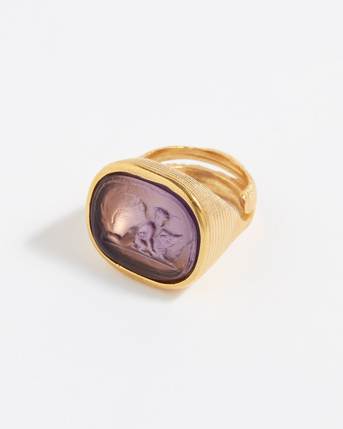 Gold ring with a purple stone on a white background