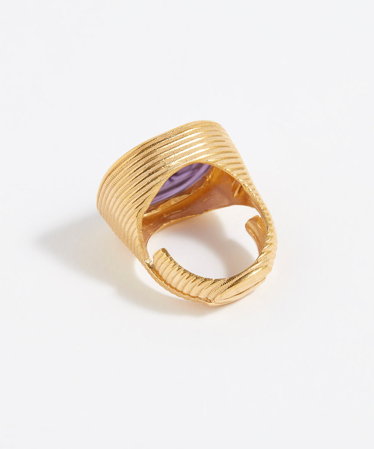 Gold ring with a purple stone on a white background