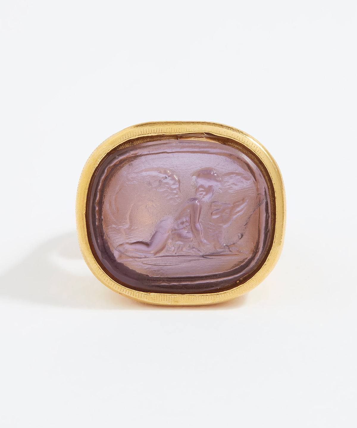 Gold ring with a purple stone featuring an engraved design on a white background