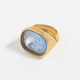 Gold ring with a blue stone on a white background